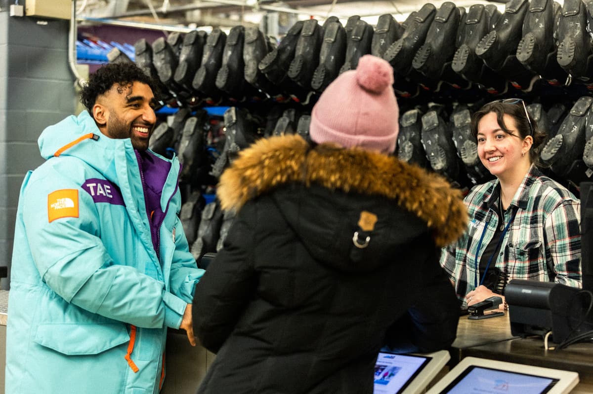 Ski rental shop with employee helping customers.