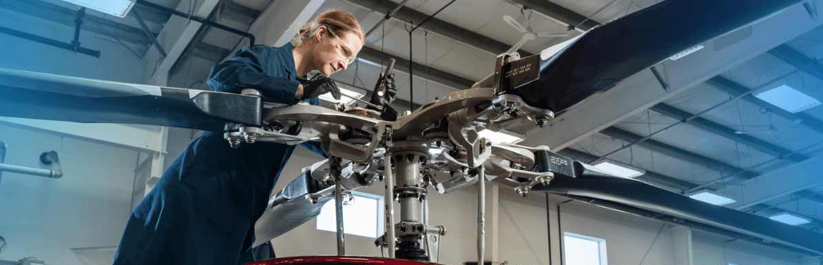 Female engineer working on a helicopter rotor.